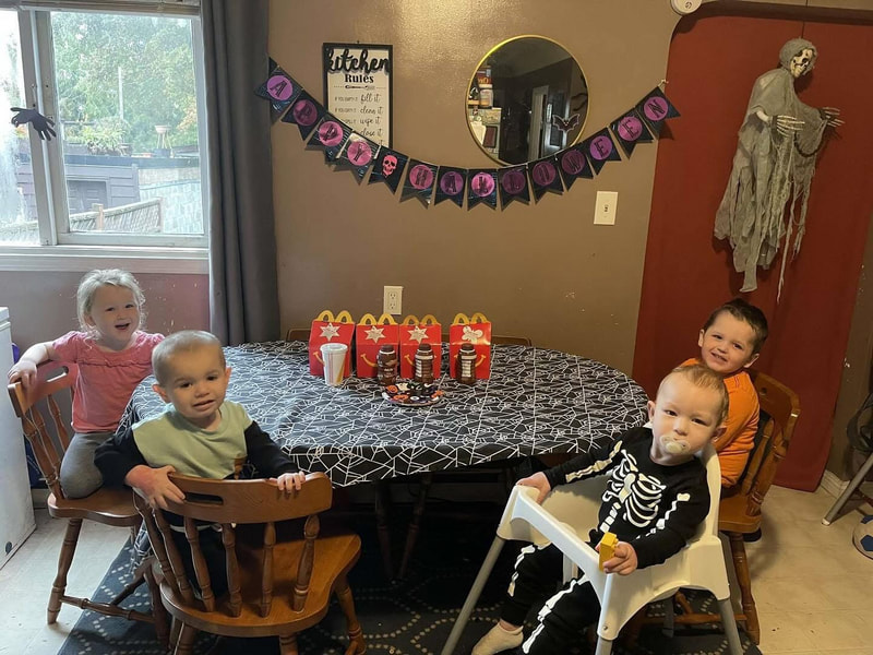 Children gathered around the daycare table for Halloween